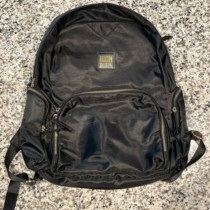 Black back pack with gold details .